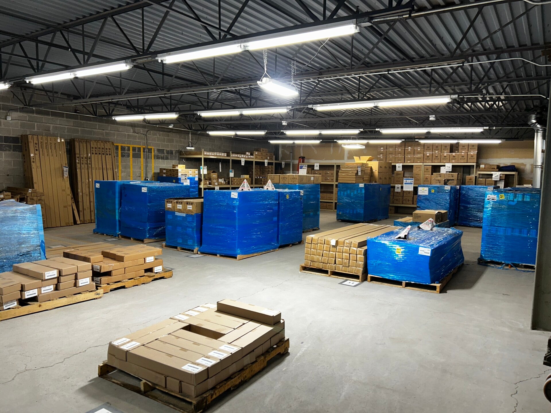 Lighting fixtures stacked on warehouse racking